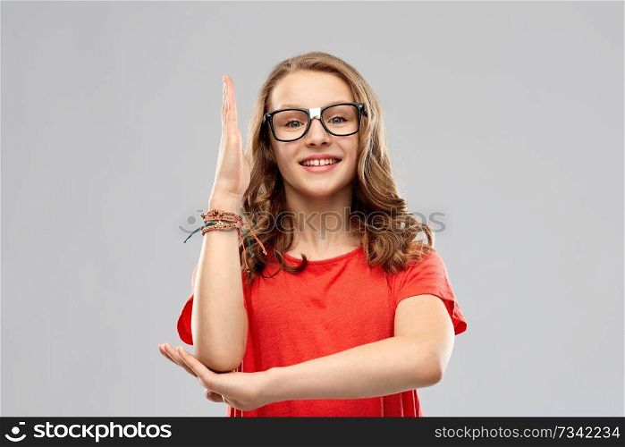 education, school and people concept - smiling teenage student girl in glasses and red t-shirt ready to answer over grey background. smiling student girl in glasses ready to answer