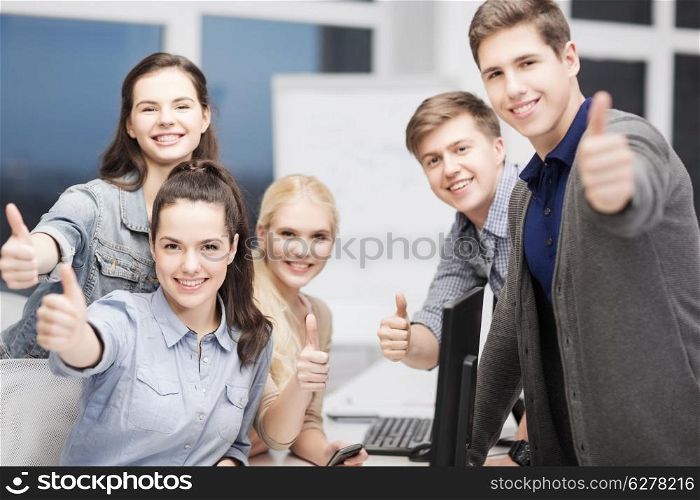 education, school and people concept - students with computer monitor and smartphones