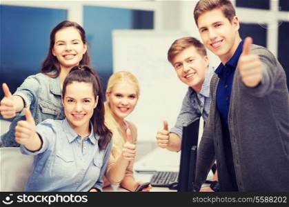 education, school and people concept - students with computer monitor and smartphones showing thumbs up