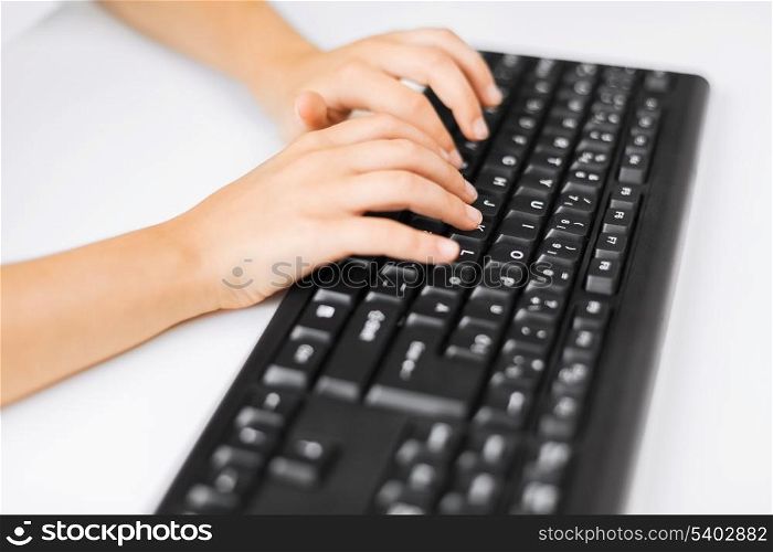 education, school and technology concept - little student girls hands typing on keyboard