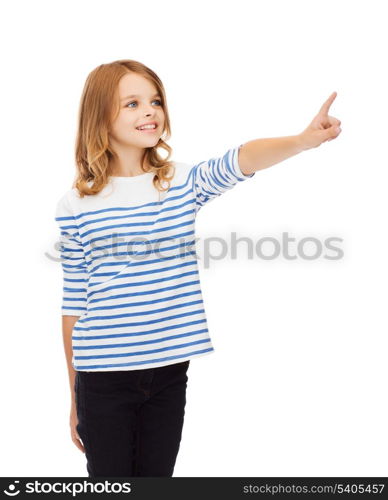 education, school and virtual screen concept - cute little girl pointing in the air or virtual screen