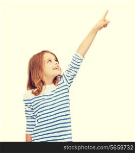 education, school and virtual screen concept - cute little girl pointing in the air or virtual screen