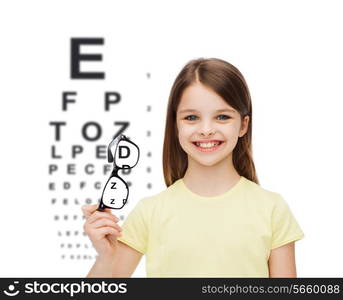 education, school and vision concept - smiling cute little girl holding black eyeglasses