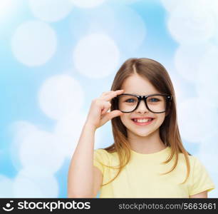 education, school and vision concept - smiling cute little girl in black eyeglasses