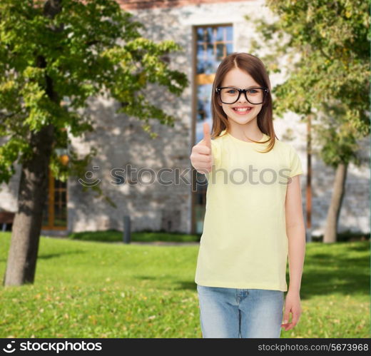 education, school and vision concept - smiling cute little girl in black eyeglasses showing thumbs up