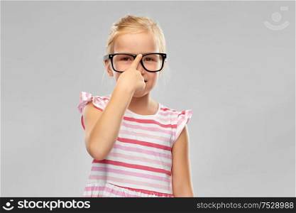 education, school and vision concept - smiling cute little girl in black glasses over grey background. smiling cute little girl in black glasses