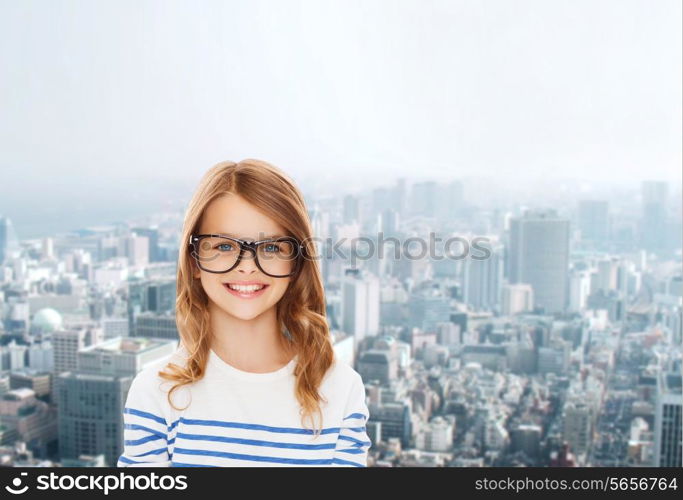 education, school and vision concept - smiling cute little girl with black eyeglasses