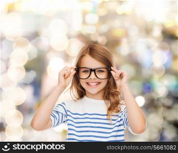 education, school and vision concept - smiling cute little girl with black eyeglasses