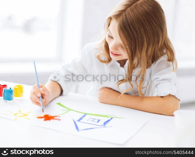 education, school, art and painitng concept - little student girl painting picture