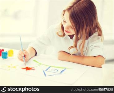 education, school, art and painitng concept - little student girl painting picture