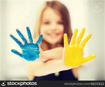 education, school, art and painitng concept - little student girl showing painted hands