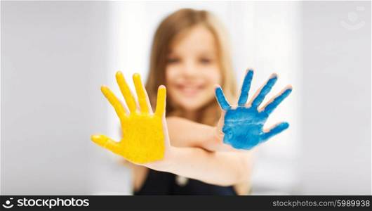 education, school, art and painitng concept - little student girl showing painted hands