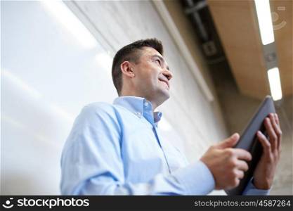 education, school, business, technology and people concept - teacher or businessman with tablet pc computer standing at white board at lecture hall