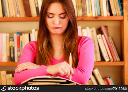 Education school concept. Intelligent female student fashion long hair girl in college library with stack books making research