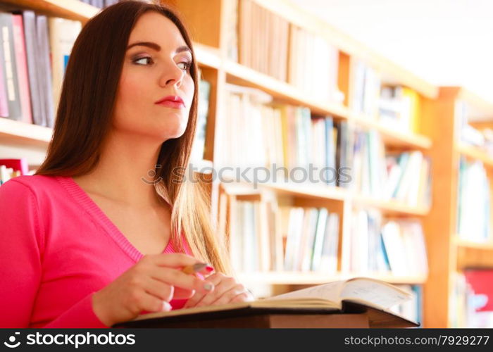 Education school concept. Intelligent female student fashion long hair girl in college library with stack books making research