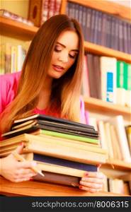 Education school concept. Intelligent female student fashion long hair girl in college library with stack books. Indoor