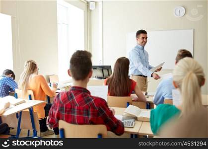 education, school, learning and people concept - group of students and teacher with test results in classroom