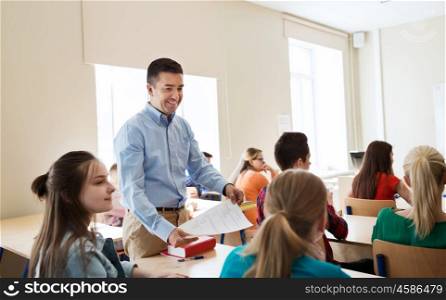 education, school, learning and people concept - group of students and teacher with test results in classroom