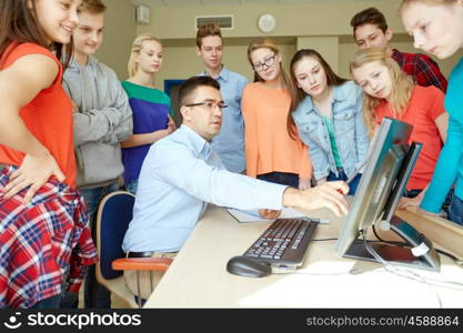 education, school, learning, teaching and people concept - group of students and teacher talking in classroom