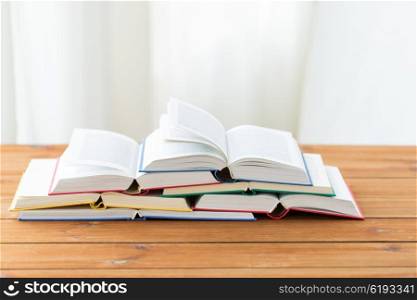 education, school, literature, reading and knowledge concept - close up of books on wooden table
