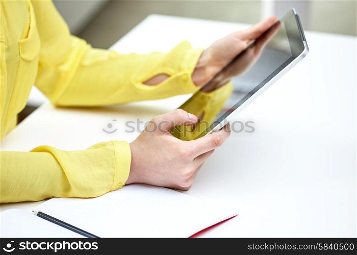 education, school, people, technology and internet concept - close up of female hands with tablet pc computer and notebook at table