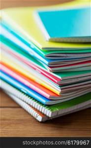 education, school supplies and object concept - close up of notebooks on wooden table