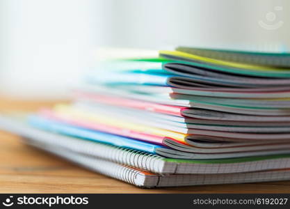 education, school supplies and object concept - close up of notebooks on wooden table