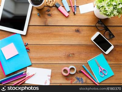 education, school supplies, art, creativity and object concept - close up of stationery and tablet pc computer with smartphone on wooden table