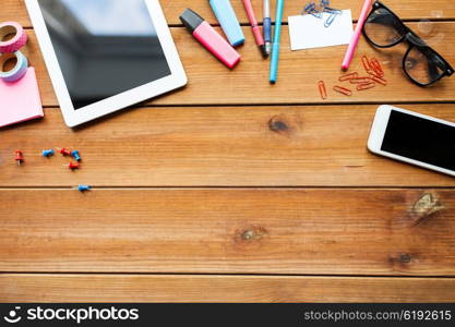 education, school supplies, art, creativity and object concept - close up of stationery and tablet pc computer with smartphone on wooden table