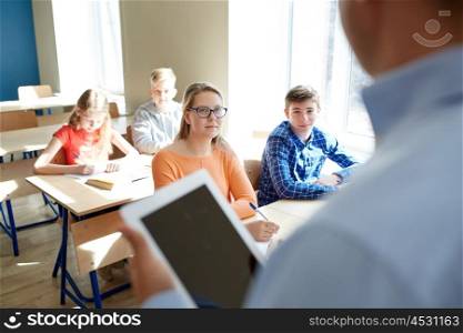 education, school, teaching, technology and people concept - group of happy students and teacher with tablet pc computer