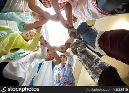 education, school, teamwork and people concept - international students making circle of hands