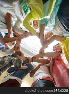 education, school, teamwork and people concept - international students making circle of hands