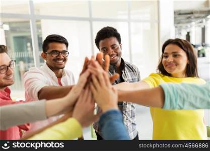 education, school, teamwork, gesture and people concept - group of international students making high five