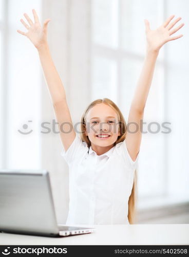 education, school, technology and internet concept - happy little girl with laptop pc at school