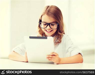 education, school, technology and internet concept - little student girl in black eyeglasses with tablet pc computer at school