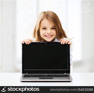 education, school, technology and internet concept - little student girl showing laptop pc at school