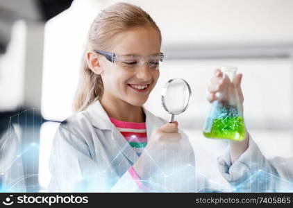 education, science and children concept - girl with magnifier studying test tube with chemical at school laboratory. girl studying test tube at school laboratory