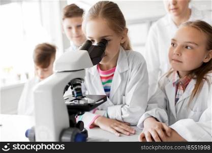 education, science and children concept - kids or students with microscope studying biology at school laboratory. kids or students with microscope biology at school. kids or students with microscope biology at school