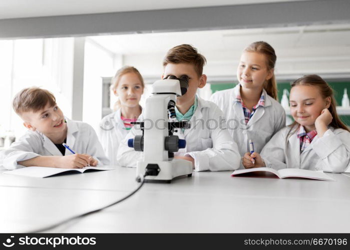 education, science and children concept - kids or students with microscope studying biology at school laboratory. kids or students with microscope biology at school. kids or students with microscope biology at school