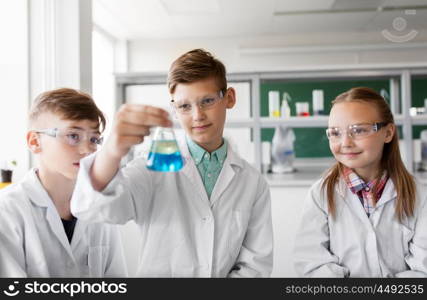 education, science and children concept - kids with test tubes studying chemistry at school laboratory. kids with test tubes studying chemistry at school. kids with test tubes studying chemistry at school