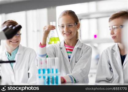 education, science and children concept - kids with test tubes studying chemistry at school laboratory. kids with test tubes studying chemistry at school. kids with test tubes studying chemistry at school