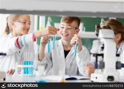 education, science and children concept - kids with test tubes studying chemistry at school laboratory. kids with test tubes studying chemistry at school. kids with test tubes studying chemistry at school