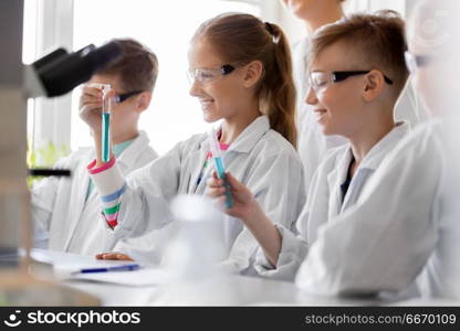 education, science and children concept - teacher and students with test tubes studying chemistry at school laboratory. teacher and students studying chemistry at school. teacher and students studying chemistry at school