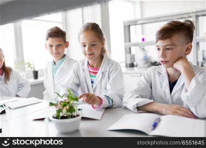 education, science and school concept - kids or students with plant at biology class. kids or students with plant at biology class. kids or students with plant at biology class