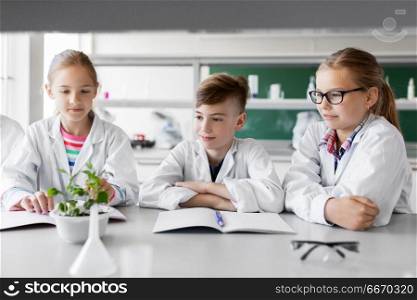 education, science and school concept - kids or students with plant at biology class. kids or students with plant at biology class. kids or students with plant at biology class