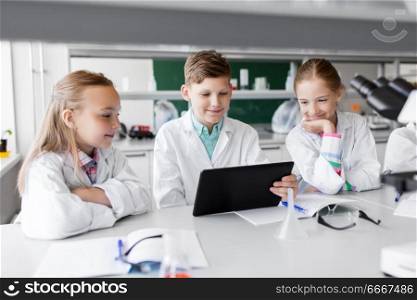 education, science and technology concept - kids with tablet pc computer studying biology or chemistry at school laboratory. kids with tablet pc at school laboratory. kids with tablet pc at school laboratory