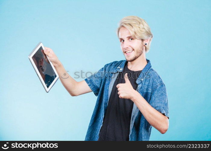 Education social media. Modern technology internet concept. Stylish handsome young guy using tablet computer, on blue color. Trendy young guy using tablet computer