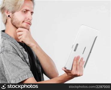 Education social media. Modern technology internet concept. Stylish handsome young man using tablet computer, thinking. Trendy young man using tablet thinking