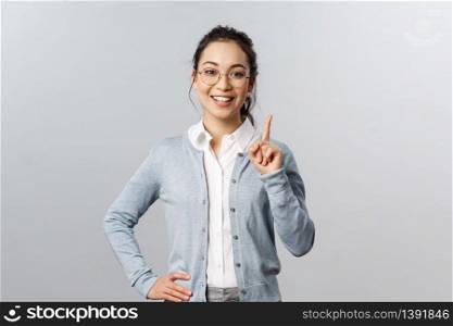 Education, studying and online classes concept. Rule number one. Cheerful pretty asian girl explaining exercise to class, raising index finger, pointing up, add a suggestion or making point, smile.. Education, studying and online classes concept. Rule number one. Cheerful pretty asian girl explaining exercise to class, raising index finger, pointing up, add a suggestion or making point, smile