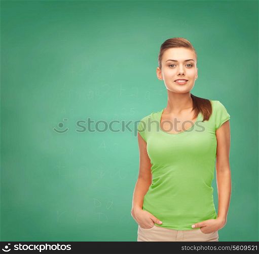education, t-shirt design and people concept - smiling young woman in blank green t-shirt